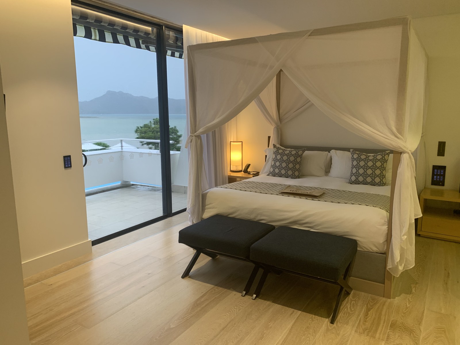 Water and the headland opposite, seen from the bed in Room 340 at InterContinental Hayman Island